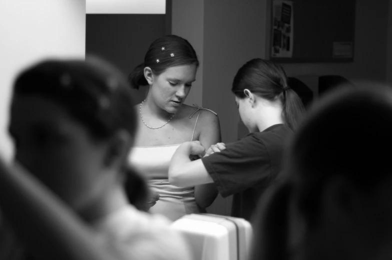 two women standing in a room looking at soing