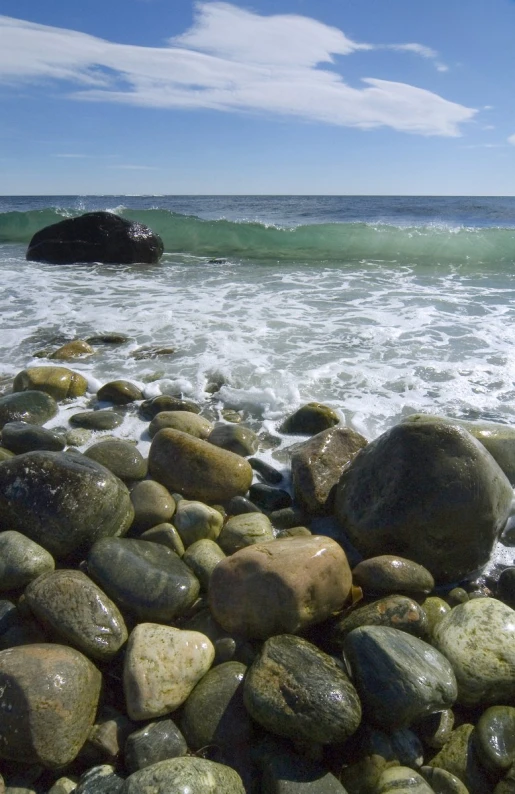 rocks and water along the shore line on a sunny day