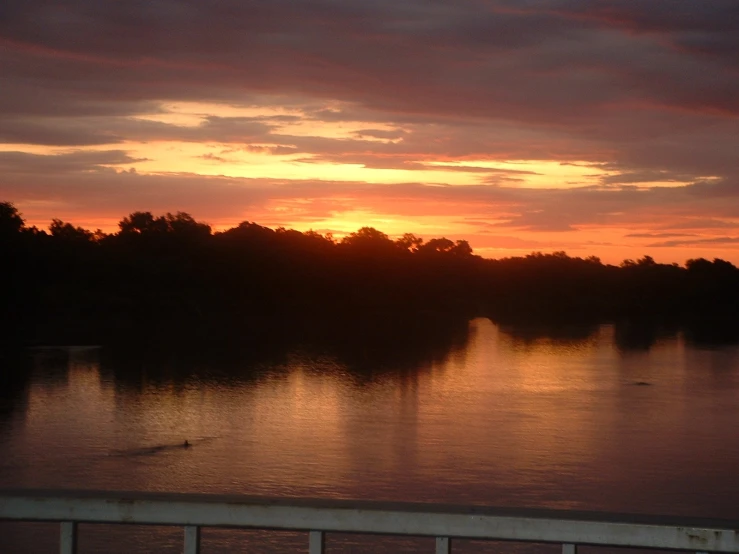 a sunset over some water near the shore