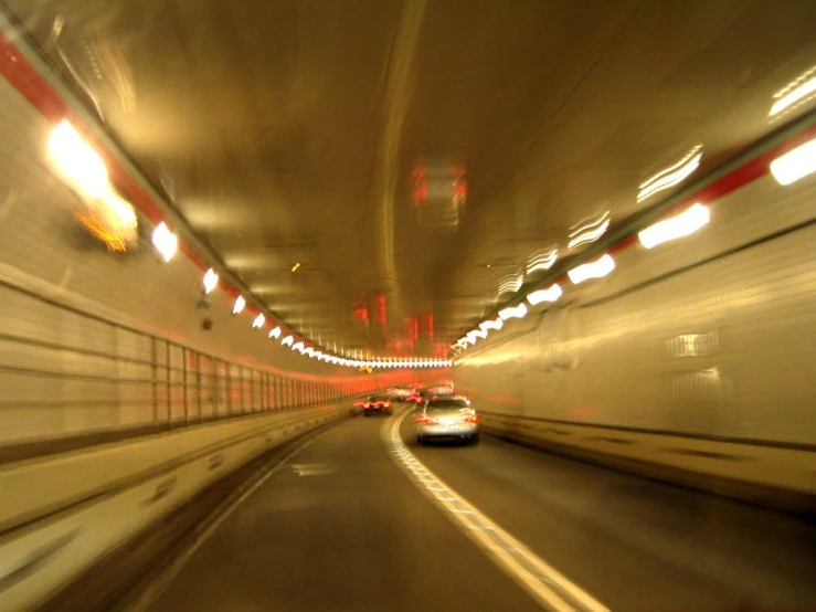 traffic is moving fast through the tunnel in the night