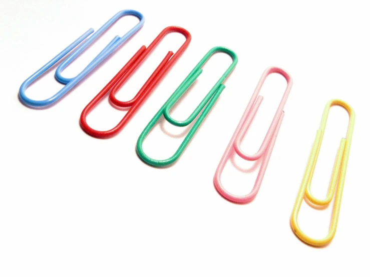 six colorful paper clips on a white background