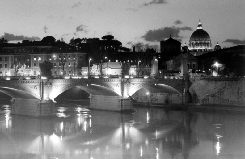 black and white image of a bridge over water at night