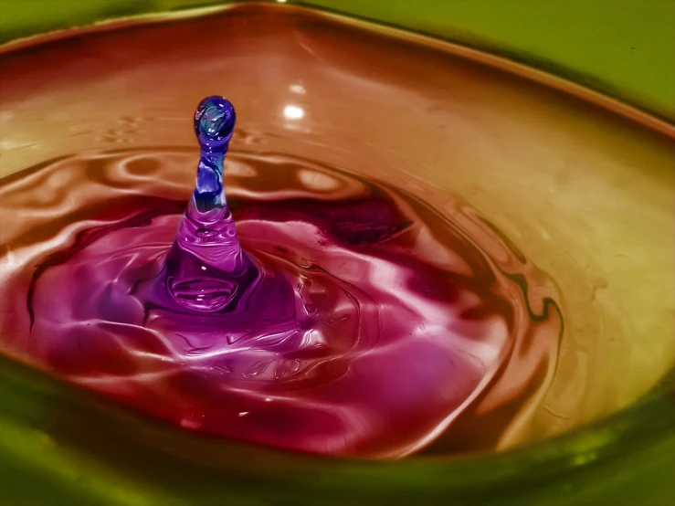 an odd colored liquid is pouring into a bowl