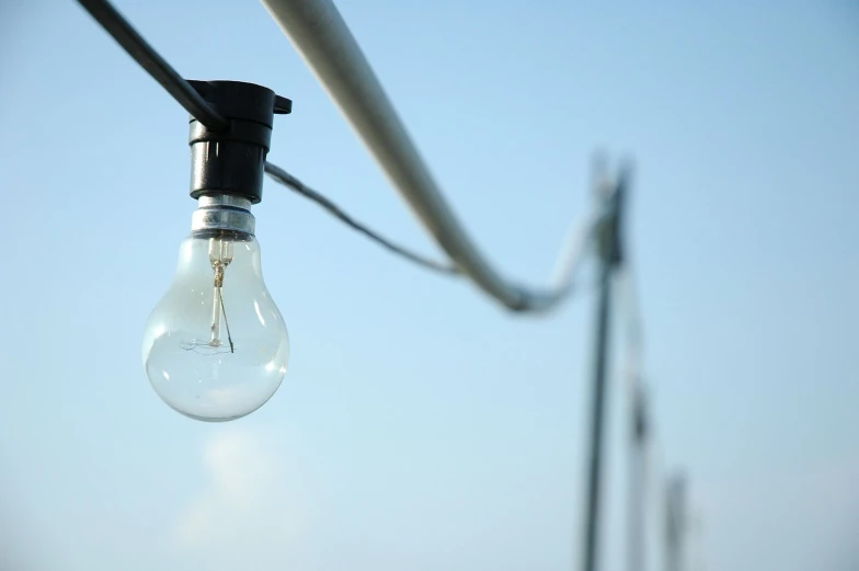 an electric lamp shines with the sky behind it