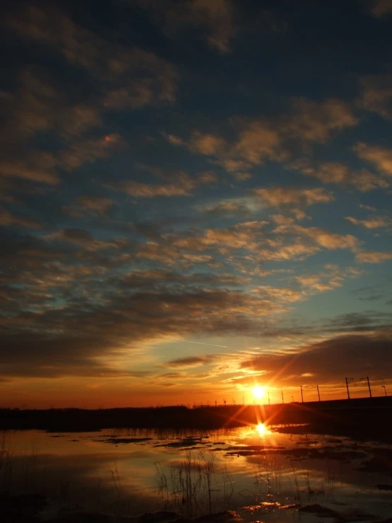 the sun is setting over some water