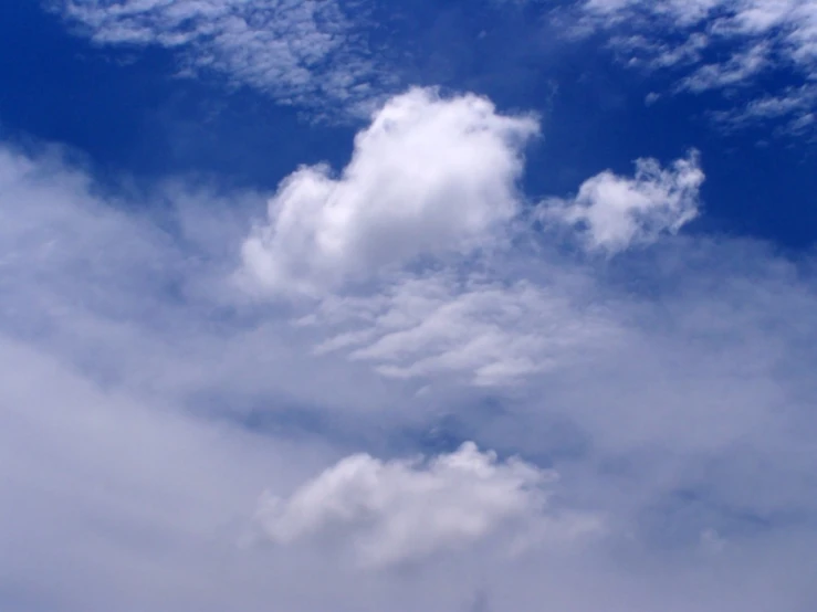 an airplane is flying in the sky with some clouds