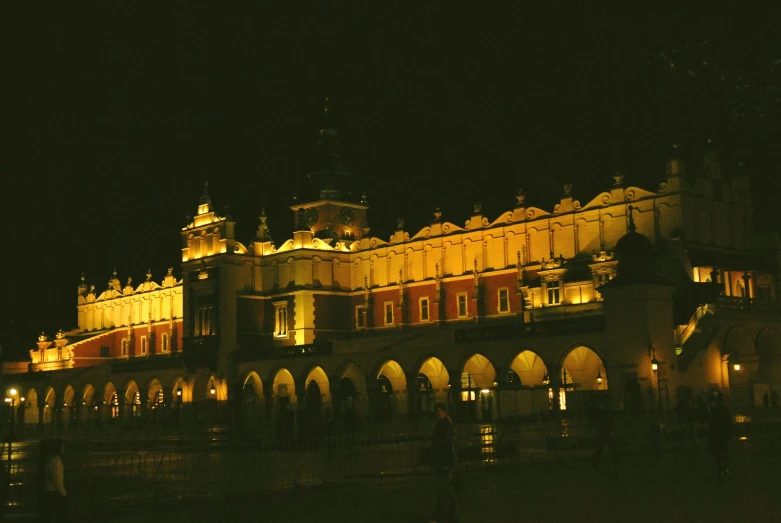 people walking outside an ornate building at night