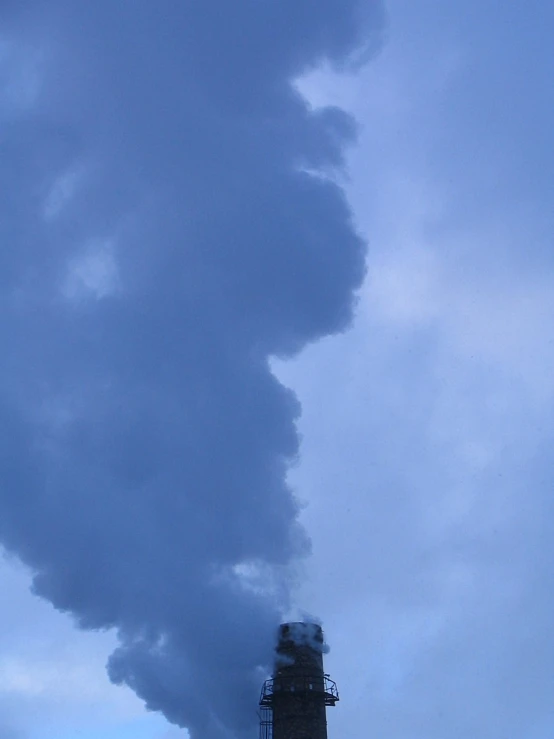 a steam locomotive emitting smoke billowing from a tower