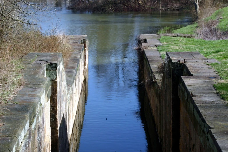 two old wooden gates next to a body of water