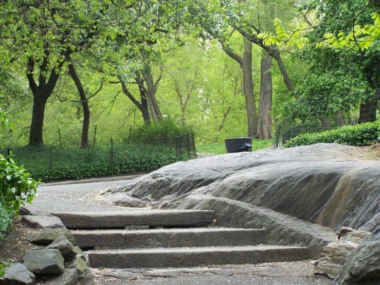 the stairs lead to a park, with boulders