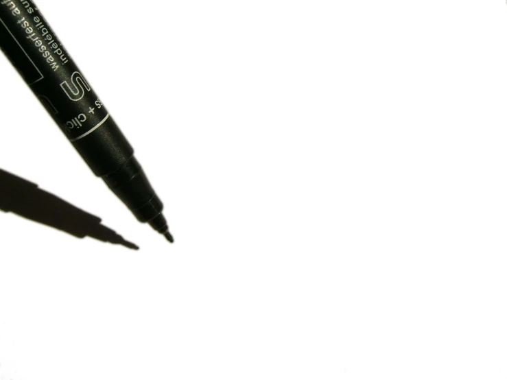 a close up view of two pens and one has a light shadow