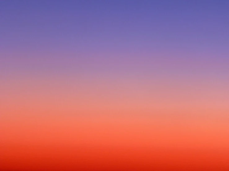 a tall plane flying in the purple and orange sky