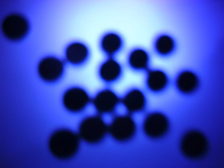 several circular balls moving on a blue surface