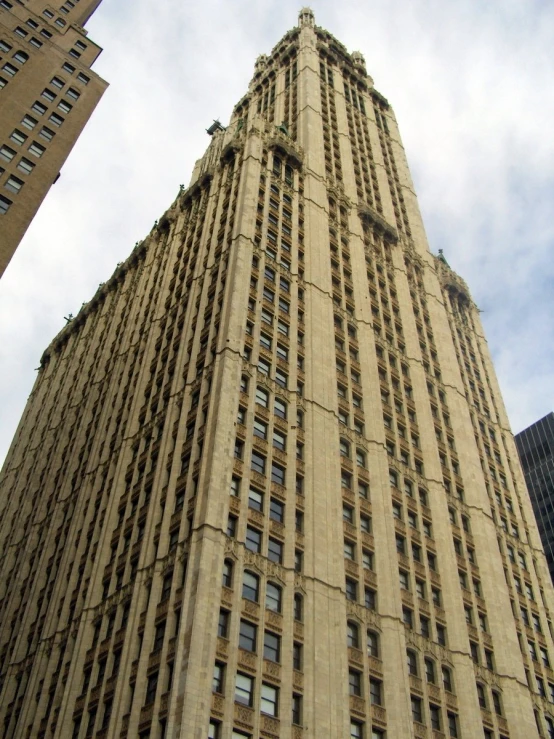 an old tall building with a few windows next to a skyscr