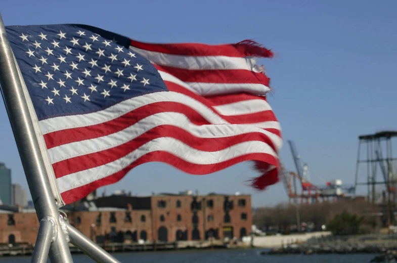 a large american flag flies in the wind