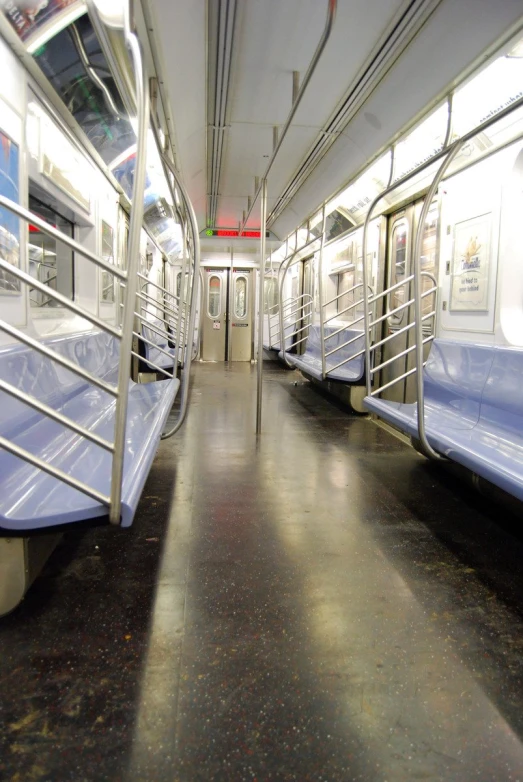 the empty subway has blue seats and railings