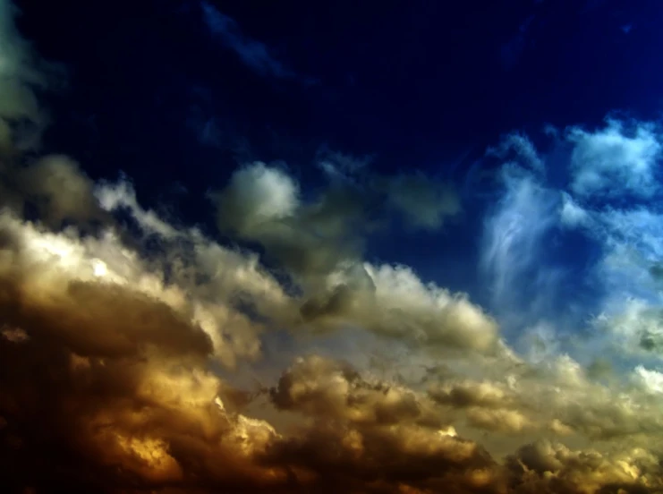 clouds, bright blue and orange with a lone plane in the background