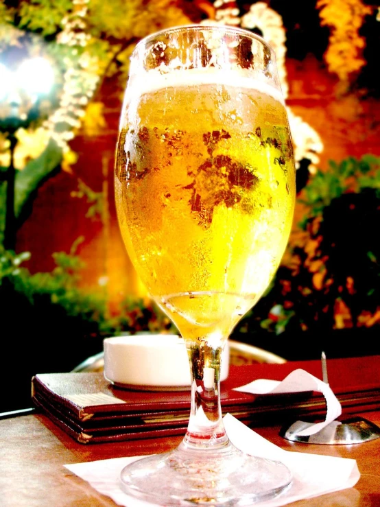 a clear glass filled with cold liquid sitting on a table