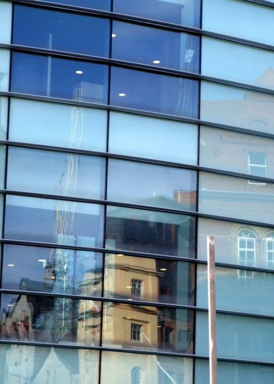 reflection of buildings seen in windows of glass building