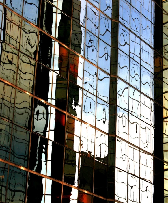 reflections of two clocks in a window of another building