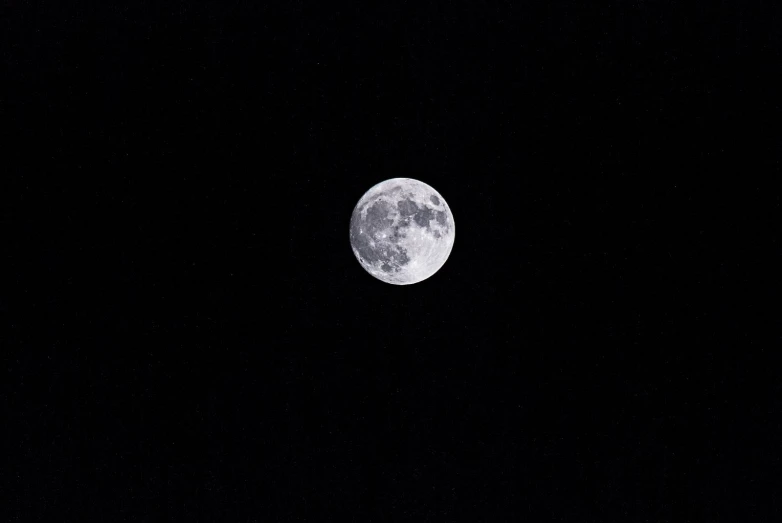 a full moon shines brightly in the dark night sky