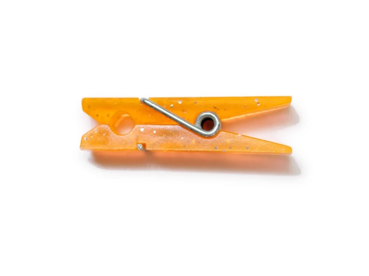 a pair of orange metal blades sit on a white surface