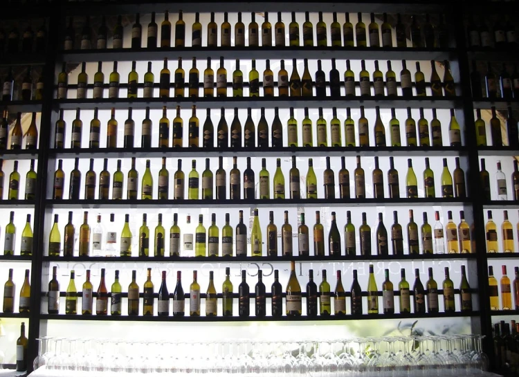 a wall of empty wine bottles in a room