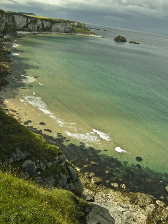 an island with rocks, sand and green grass