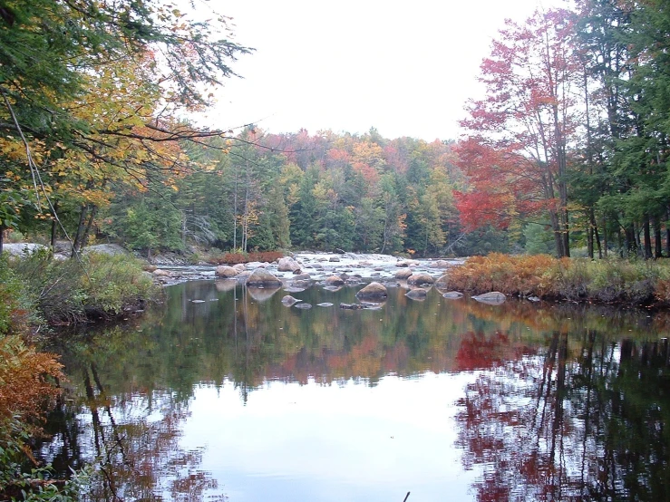 a lake surrounded by rocks and autumn trees