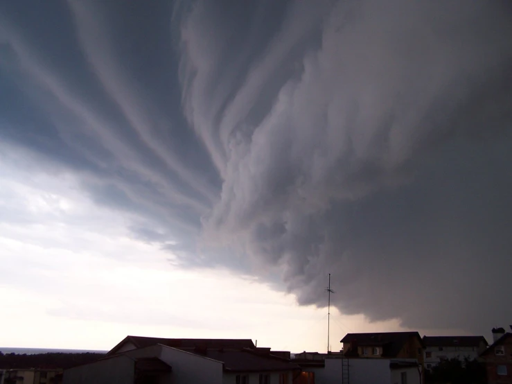 an extremely large cloud is seen over some houses