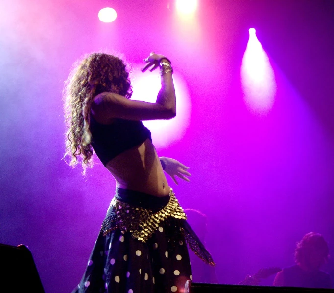 a lady standing on top of a stage on a purple and white stage