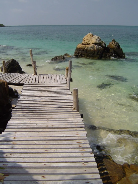 a wooden dock near the ocean near rocks