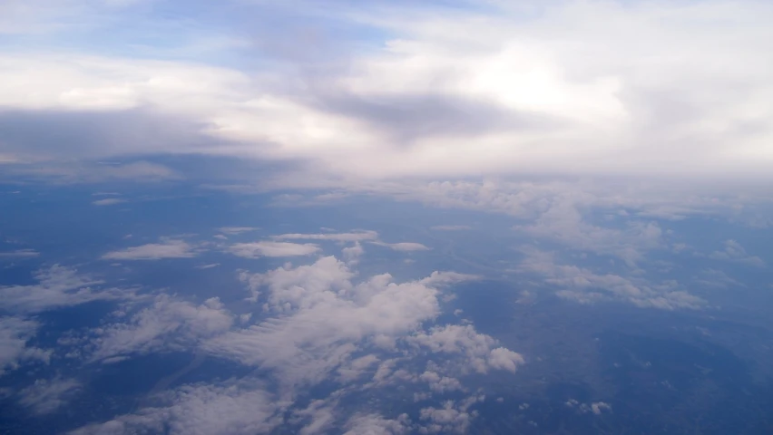 a plane is flying in the sky and clouds above