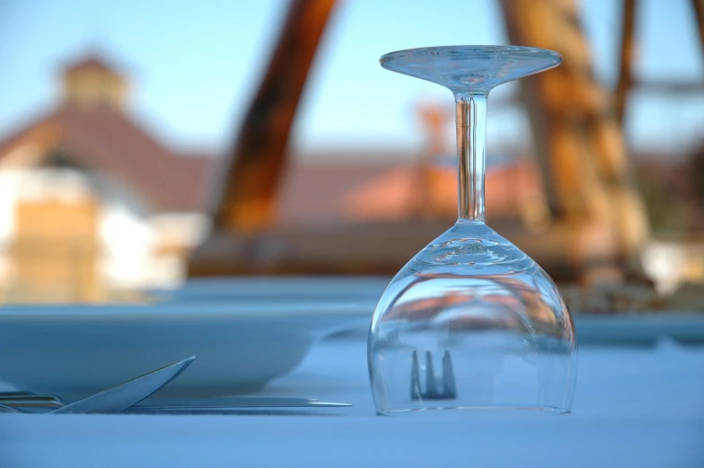 a white table topped with a glass filled with wine