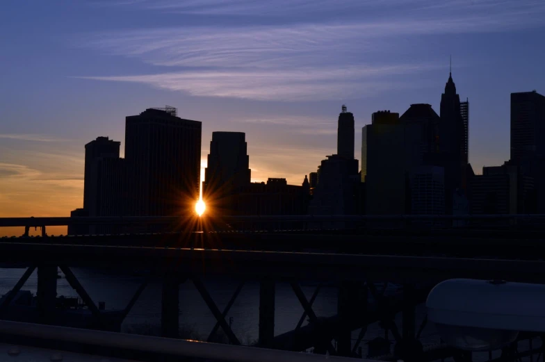 the sun is setting behind a city and river