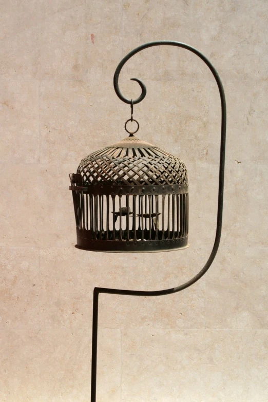 a black metal birdcage with a handle attached