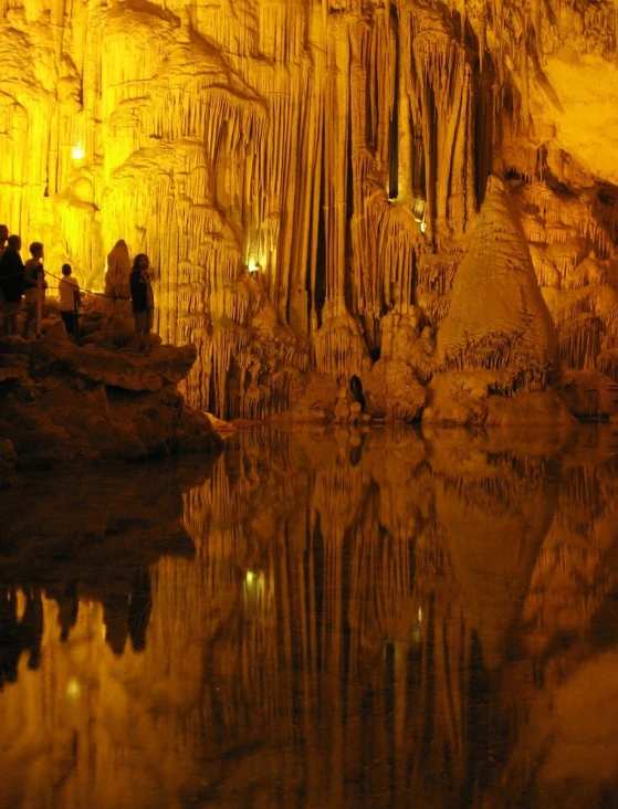 a group of people are walking into the cave