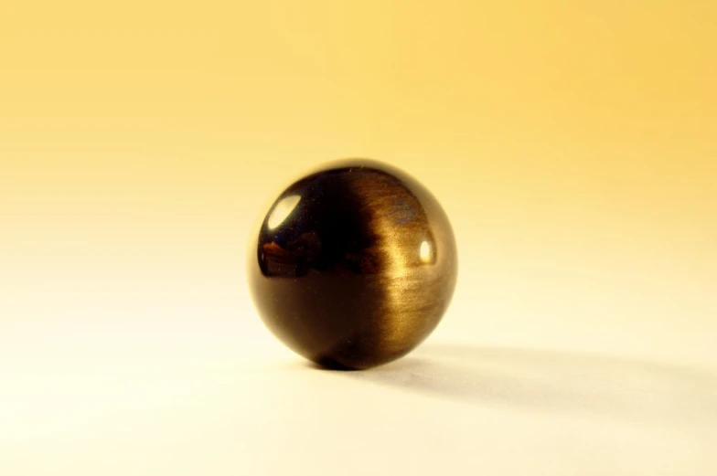 an image of a gold sphere sitting on the ground