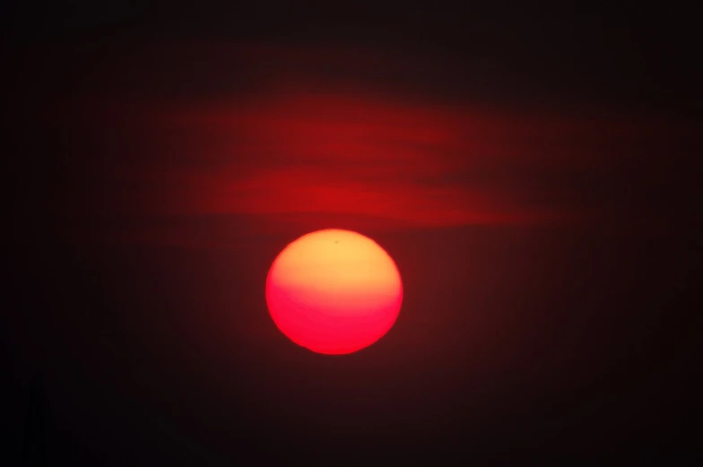 a red and orange sky with an image of the sun in front