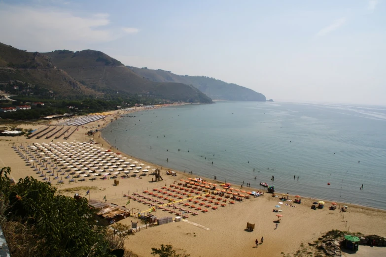 a beach that has lots of chairs and umbrellas set up in it