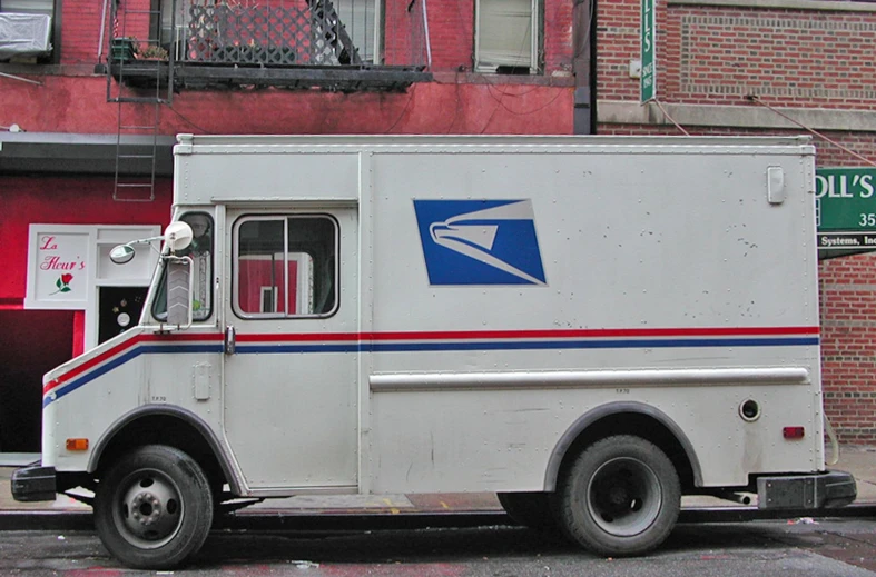 a mail truck sits on the side of the street