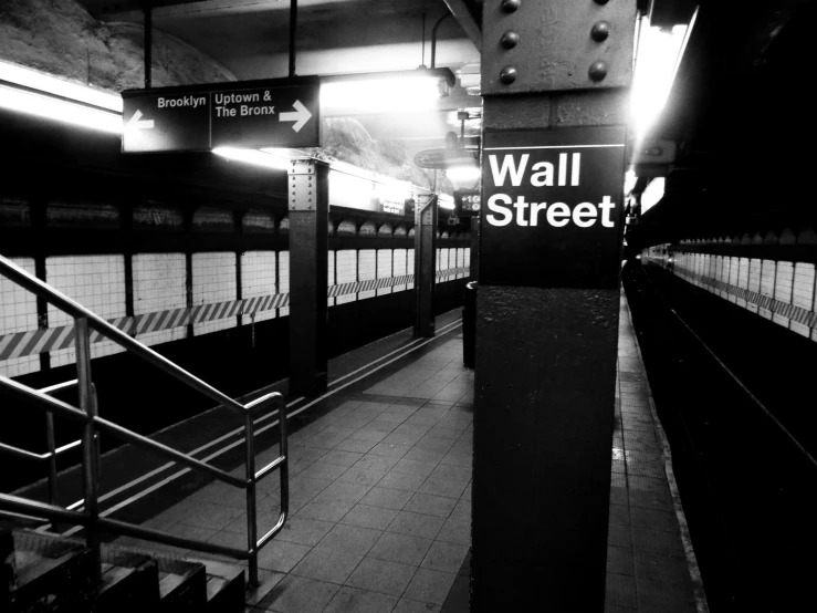 an empty subway area with some stairs and railing