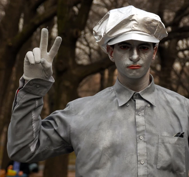 a man in an odd looking outfit holding up a peace sign