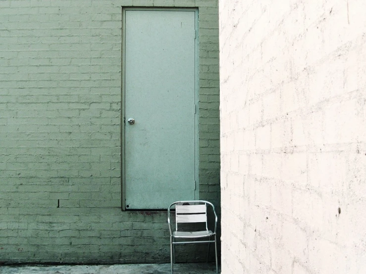 a door to a building behind a chair