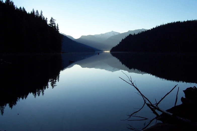 the sun is shining down on the mountain lake