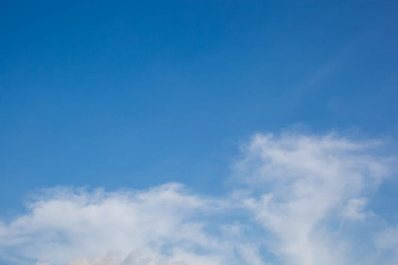 some type of kite with white and red clouds in the sky