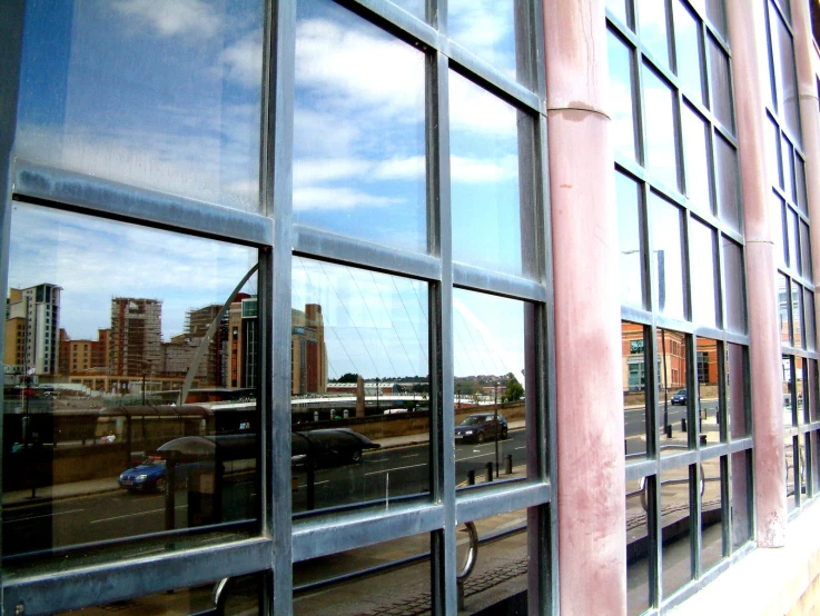 a large window that has reflection of a city and train
