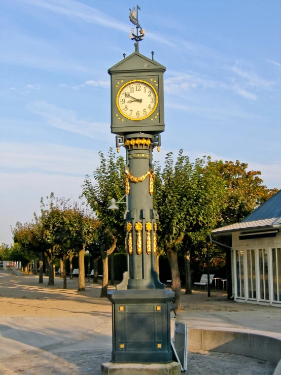 a large clock on a post in front of some buildings