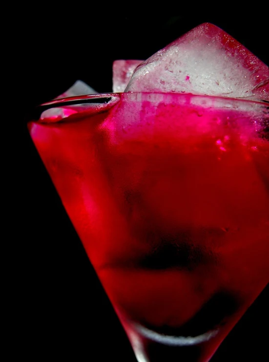 a red drink with ice and garnishes on it
