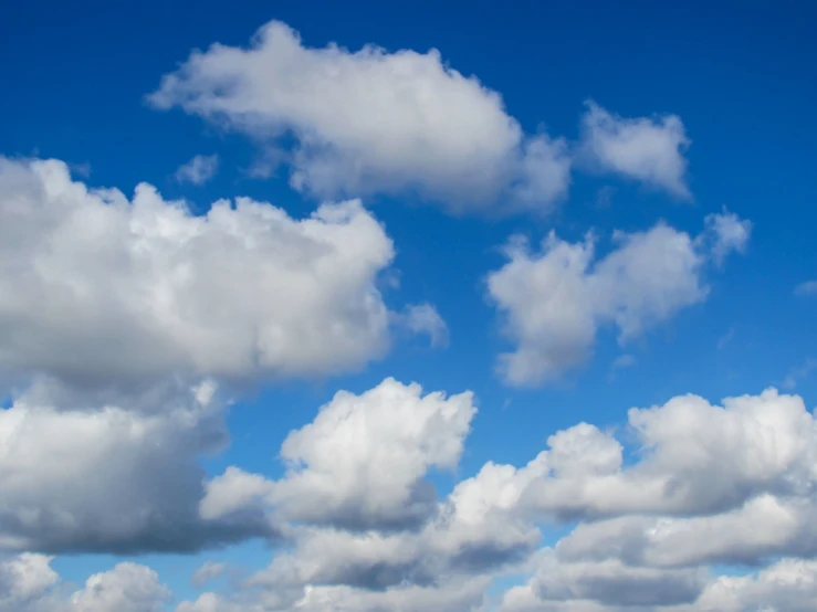 a small plane flying through the air under cloudy skies